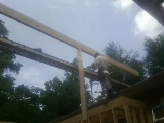 Carpenter setting a ridge beam over a new addition frame — Ice Dam Removal by Roofing Brothers in Carbonado