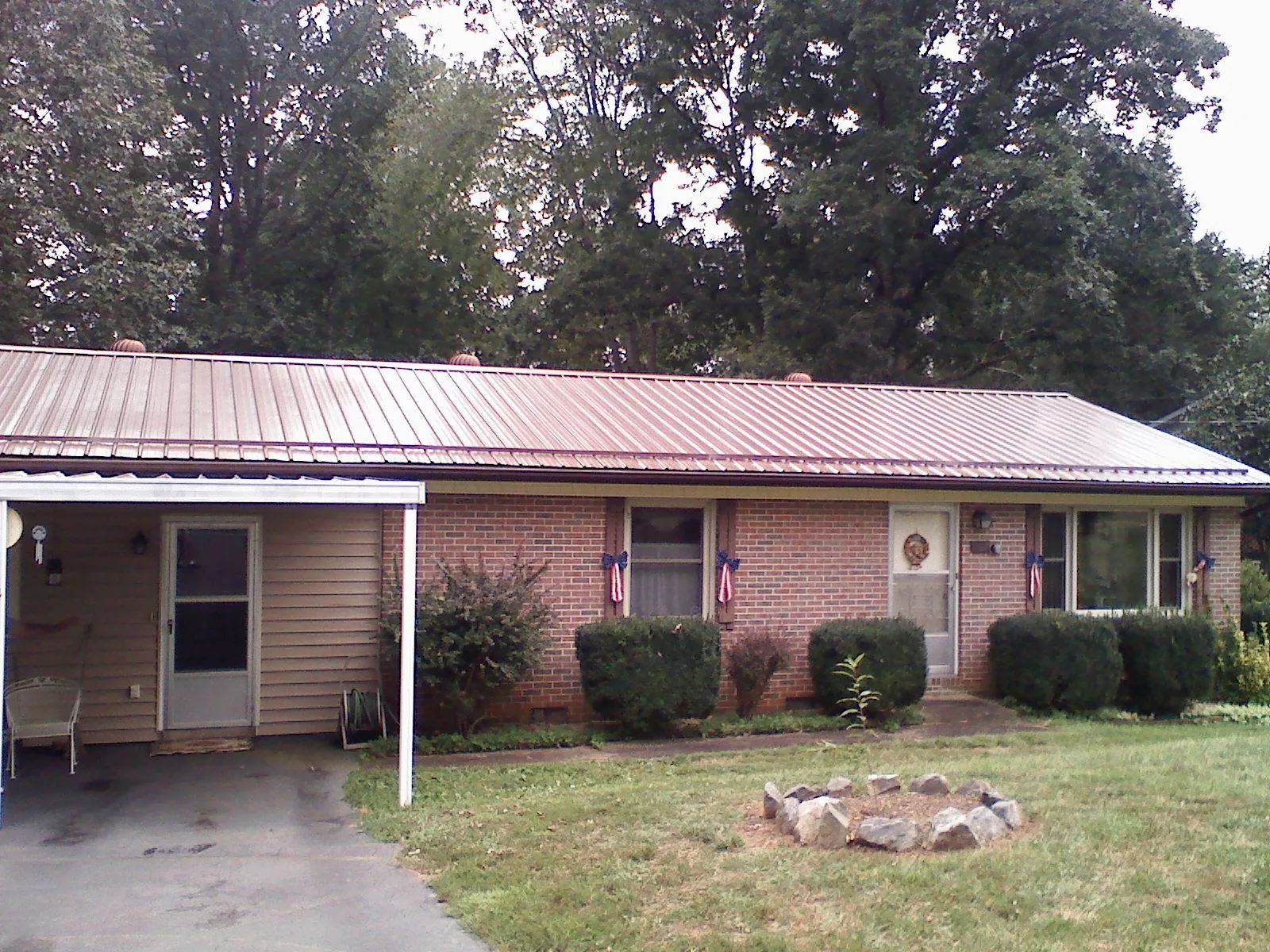 Bronze metal roof and carport on a brick ranch home — Roof Repair work by our crew in Carbonado